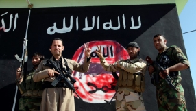 Christian fighters defiantly hoist their flag above town recaptured from ISIS