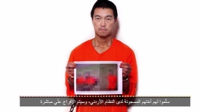 Japanese hostage \'beheading\' claimed by ISIS in new video; Kenji Goto shown with photo of slain hostage Haruna Yukawa