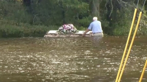 Pastor wades through fetid South Carolina floodwaters to retrieve floating casket